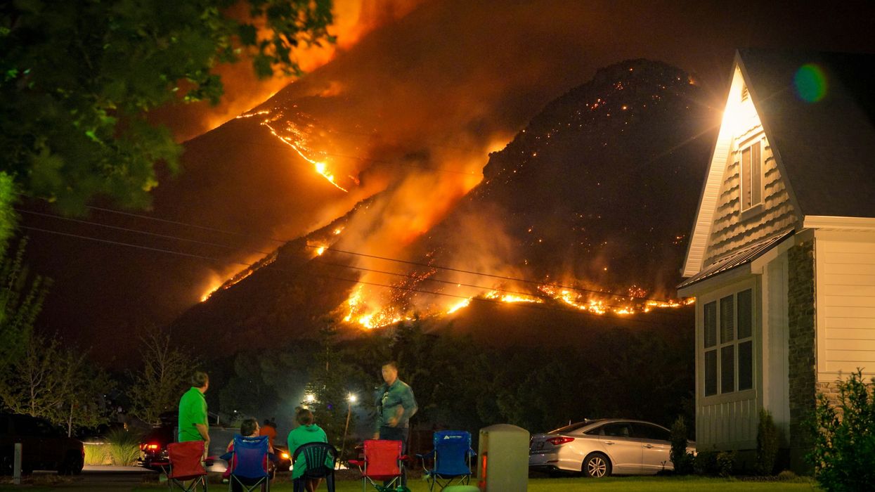 A family watches a nearby wildfire