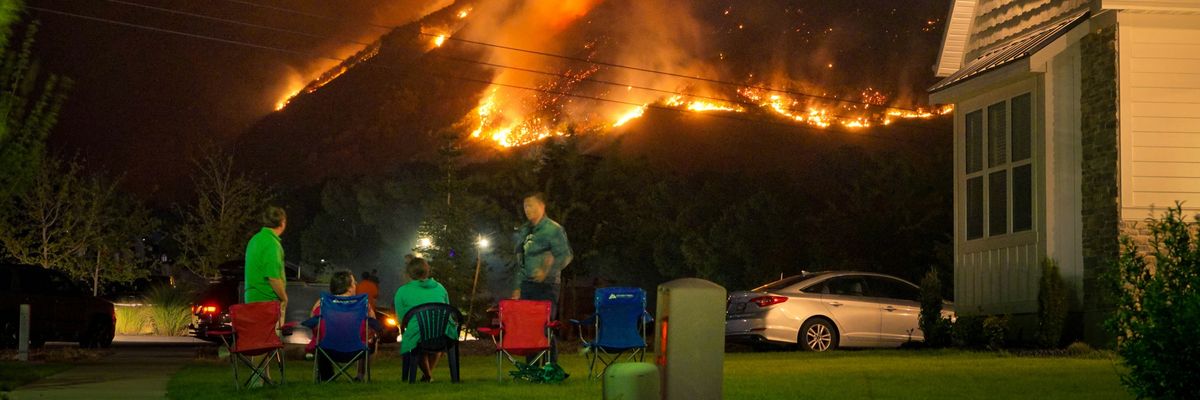 A family watches a nearby wildfire